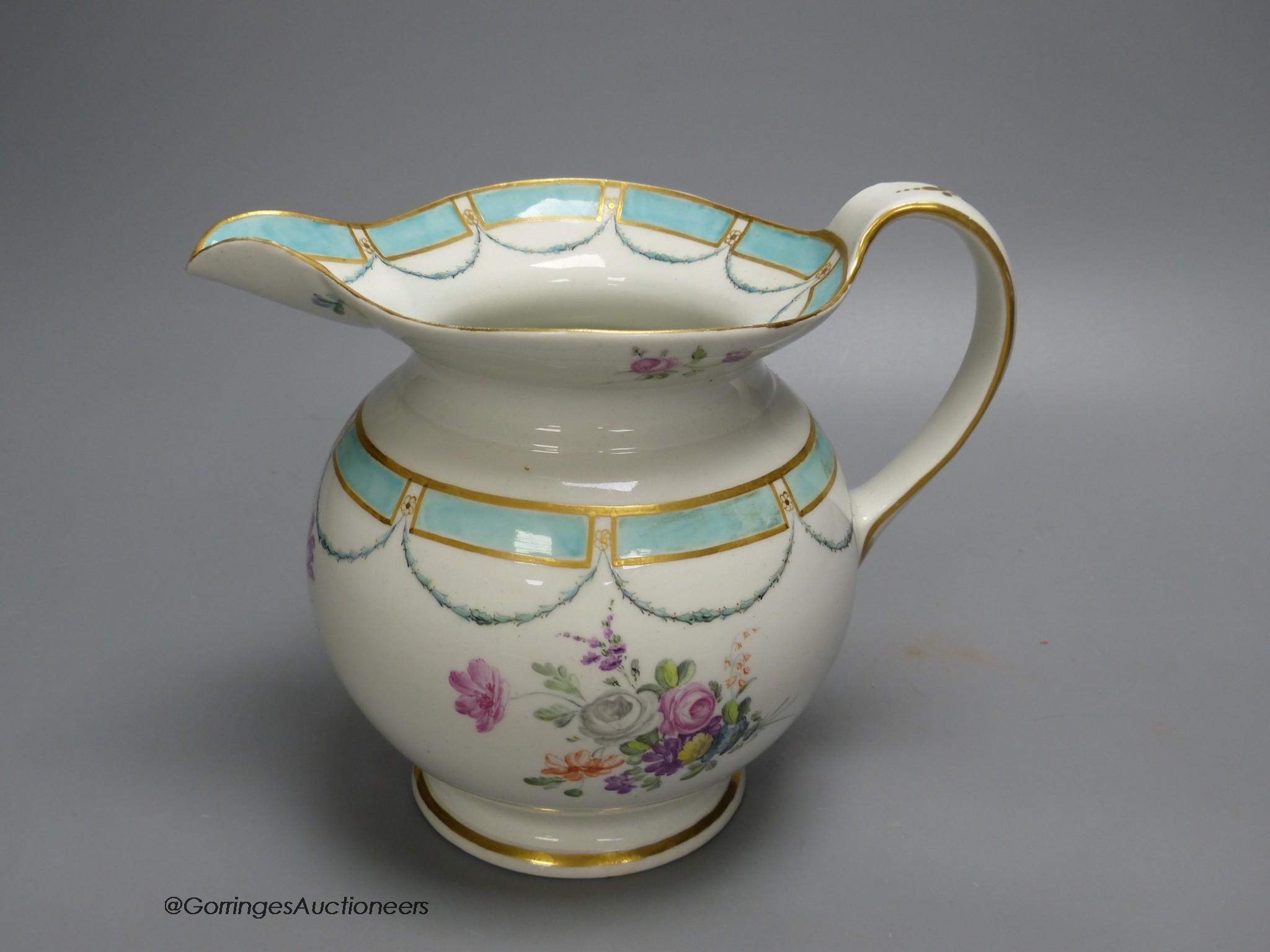 A Chelsea Derby jug of most unusual shape painted with flowers and a turquoise border, 18cm high